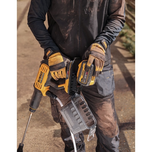 DEWALT DCMPW1000N, DCMPW1000N-XJ cordless tool held by worker in gloves. Photography product category.