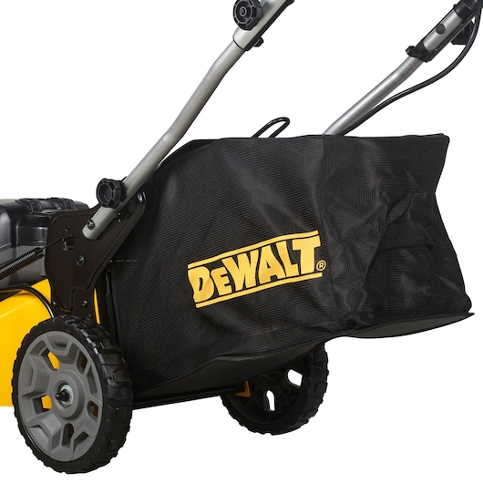 Close-up of DEWALT lawn mower side view, showing wheels, handle, and branded grass collection bag.