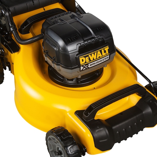 Close-up of a DEWALT DCMW564N yellow cordless lawn mower with brushless motor detail.
