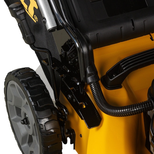 Close-up of a DEWALT lawn mower showing wheel, handle, and yellow body details.