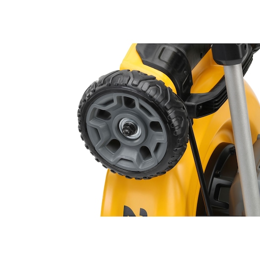 Close-up of a grey wheel on a yellow DEWALT lawn mower, highlighting the sturdy tread and plastic body.