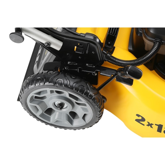 Close-up of a yellow DEWALT lawn mower wheel and height adjustment mechanism.