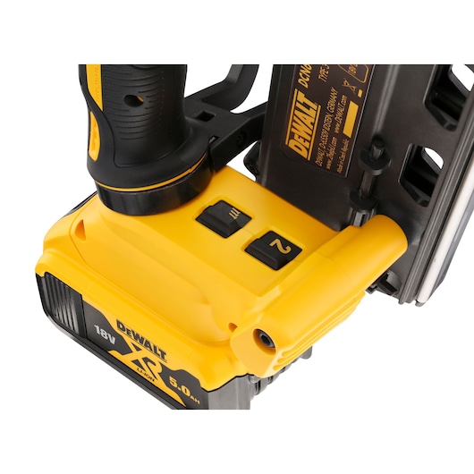Close-up of a DEWALT 18V XR nailer showing controls and battery compartment.