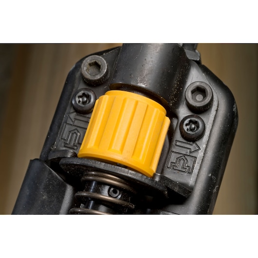 Close-up of a DEWALT tool featuring a yellow adjustment knob and two screws, with directional arrows visible.