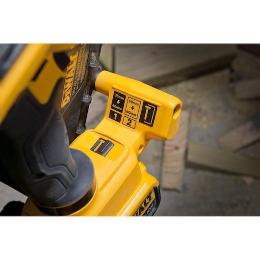 Close-up of DEWALT DCN693N tool showing controls and labeled settings for nail sizes and modes.