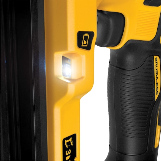 Close-up of yellow DEWALT tool handle with LED light and battery indicator, showing textured grip.