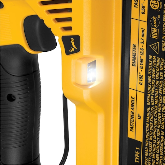 Close-up of DEWALT nailer DCN890N handle with LED light and yellow safety instructions label visible.