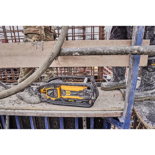 DEWALT Power Shift device on a construction site platform surrounded by workers and concrete materials.