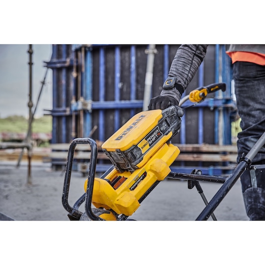 DEWALT Power Shift tool in use outdoors at a construction site with a worker adjusting the equipment.