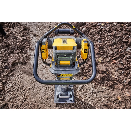 DEWALT DCPS660N tool with yellow and black handles on a dirt ground, viewed from above.
