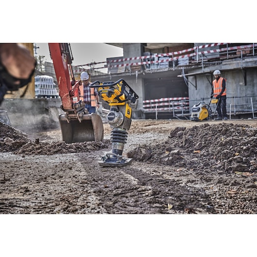 DEWALT DCPS660N tool used at a construction site, with workers and machinery on a dirt surface.