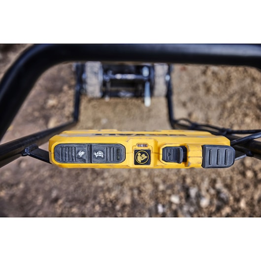 Close up of DEWALT control panel with buttons and icons, viewed from above, on a construction tool outdoors.