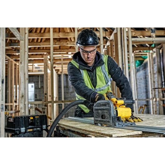 DEWALT DCS520T2-XE, DCS520T2 saw used in construction. Worker cuts wood indoors. Photography product category.