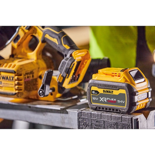 DEWALT cordless tool and XR FlexVolt 18V/54V lithium-ion battery on a metal surface at a workspace.