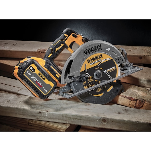 Cordless DEWALT circular saw with 18V XR FLEXVOLT battery, placed on wooden planks.