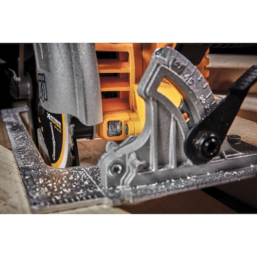 Close-up of a DEWALT circular saw cutting wood, showing the bevel adjustment and saw blade.