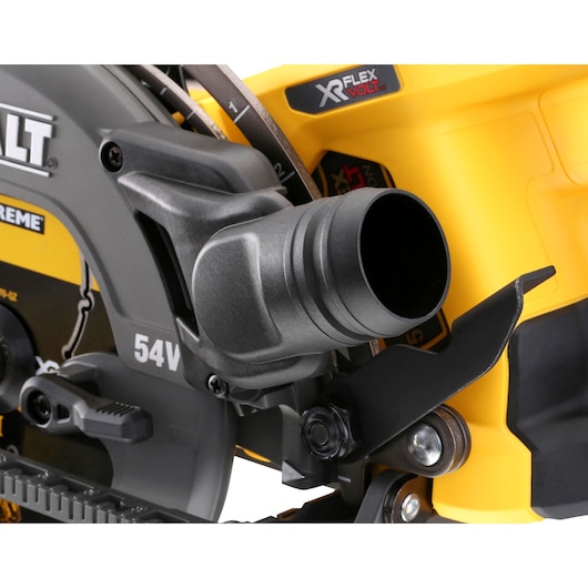 Close-up of a DEWALT DCS577T2 cordless circular saw focusing on the dust extraction port and blade area.