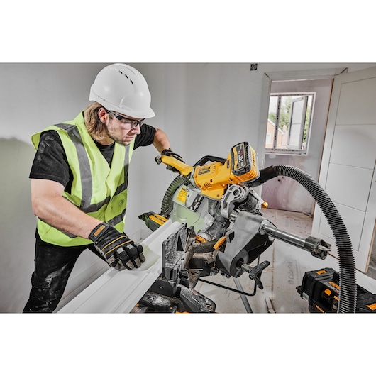 DEWALT saw DCS781X2-QW, DCS781X2 in use on construction site by worker in safety gear.