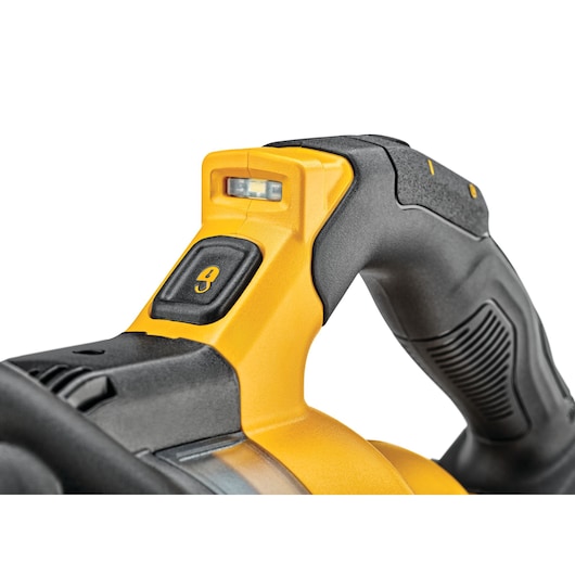 Close-up of a DEWALT power tool handle featuring a yellow and black ergonomic grip, integrated LED light, and a prominent lock button.
