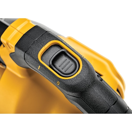 Close-up view of the power switch on a yellow and black DEWALT tool, showing textured grip and marked positions.