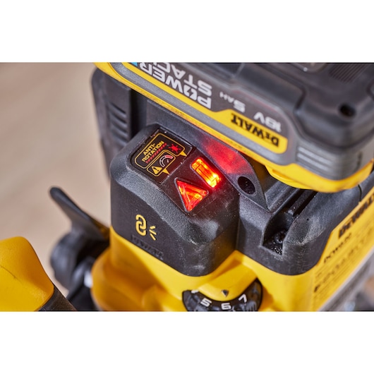 Close-up of DEWALT PowerStack rechargeable tool with red indicator lights and control stickers.