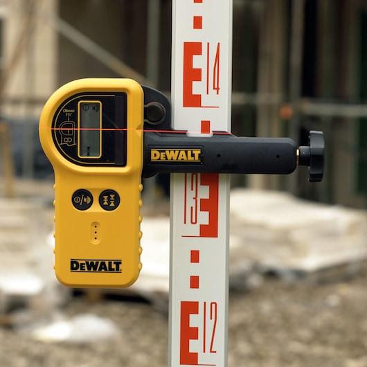 DEWALT laser detector for photography, models DE0772 and DE0772-XJ, mounted on measuring rod.