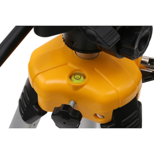 Close-up of DEWALT tripod base with level indicator and adjustment knobs, used for photography and surveying.