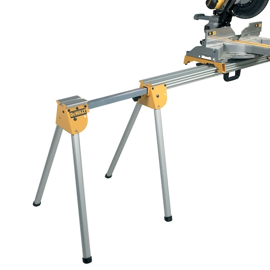 DEWALT DE7031 metal work stand extension with yellow ends and folding legs, attached to a saw.