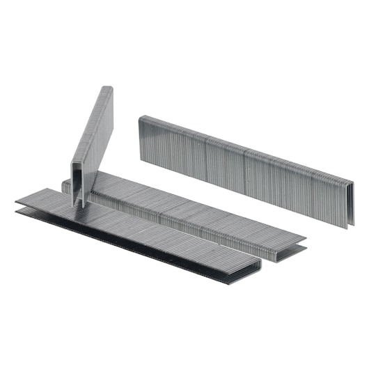 Multiple strips of metal staples arranged on a white surface, shown from an angle.