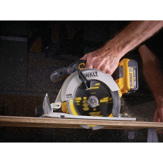 DEWALT cordless circular saw cutting wood, with sawdust flying as the blade spins.
