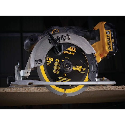 DEWALT DT1471 cordless circular saw cutting wood, showing blade details and battery pack.
