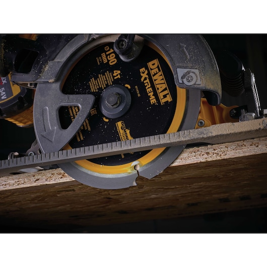 Close-up of a DEWALT Extreme circular saw cutting through a piece of wood.