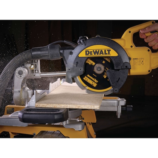 DEWALT circular saw cutting a wooden board, dust is visible, close-up of tool in use.