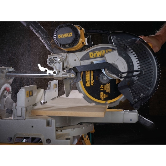 DEWALT circular saw cutting a wooden board with dust visible during operation.