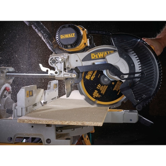 DEWALT saw cutting wood, dust visible. Close-up of blade and machine in action, used for woodworking tasks.