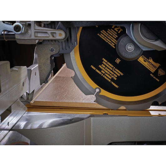 Close-up of a DEWALT saw cutting flooring material with a DT1474 blade, showing precision cutting action.