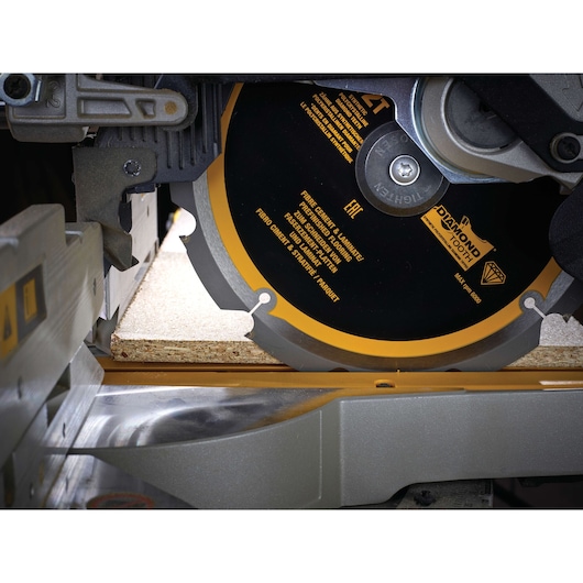DEWALT saw blade cutting laminate flooring. Close-up of blade and material being cut.
