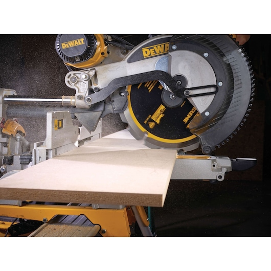 DEWALT circular saw cutting a wooden board in a workshop setting with visible dust.