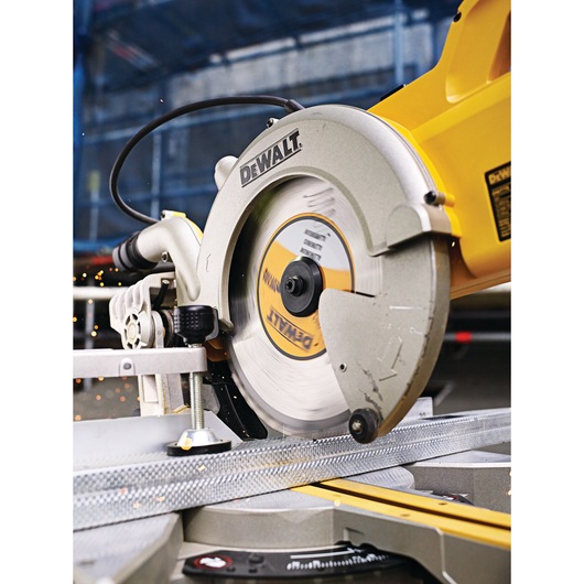 DEWALT circular saw cutting metal in workshop, close-up showing blade and sparks.