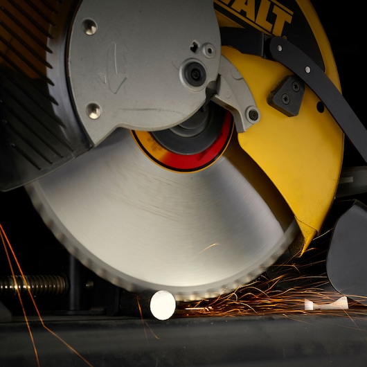 Close-up of a DEWALT circular saw cutting metal, sparks flying from contact with the workpiece.