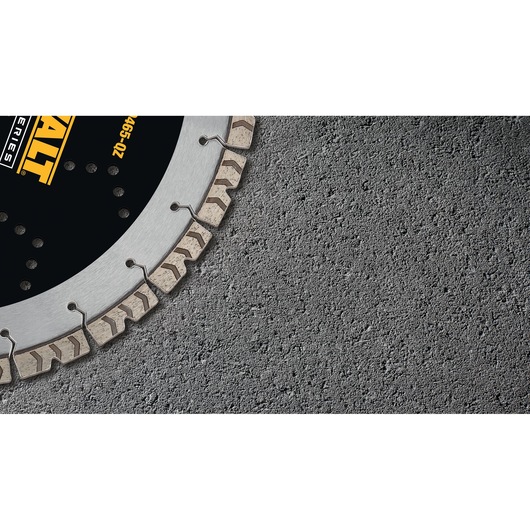 Close-up of a DEWALT diamond saw blade cutting grey textured concrete surface.