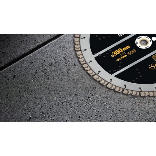 Close-up of a DEWALT DT20465 diamond saw blade cutting through concrete surface.