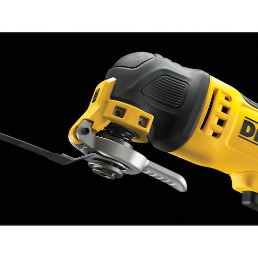 Close-up of a yellow DEWALT oscillating tool with attached blade on black background.