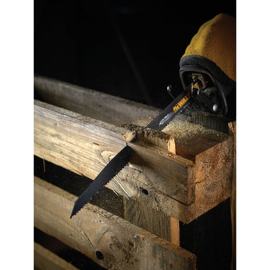 DEWALT saw blade cuts through wooden pallet, creating sawdust during woodworking.