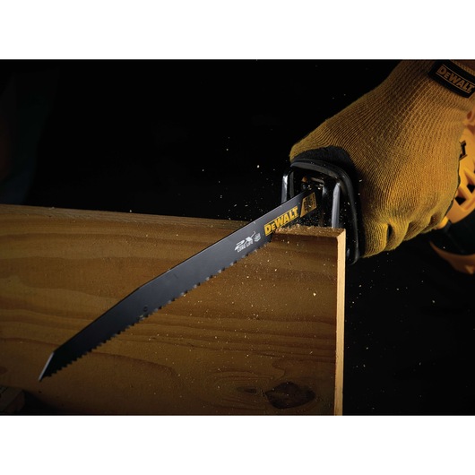 DEWALT saw blade cutting wood, used with gloved hand. Sawdust is visible during action.