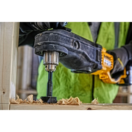 DEWALT DT4582 drill bit in use, drilling a hole in wood with a cordless drill, wood shavings visible.