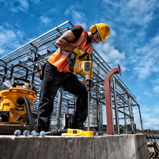 DEWALT DT60814, DT60814-QZ drill used by worker at construction site, with safety gear and tools visible.