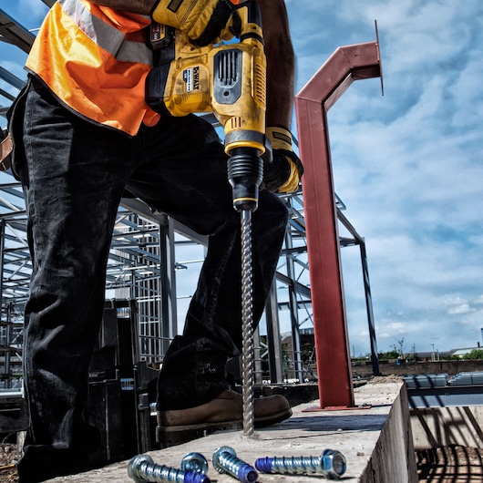 DEWALT DT60814, DT60814-QZ drill bit used on a construction site by worker in safety gear.