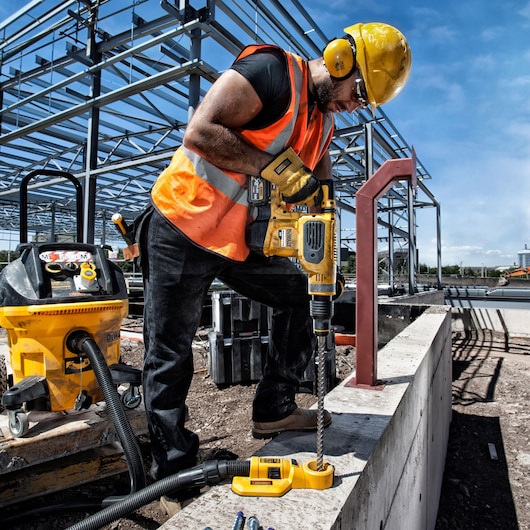DEWALT DT60814, DT60814-QZ drill used on a construction site by worker in safety gear.