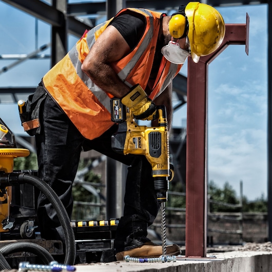DEWALT DT60814, DT60814-QZ drill used on construction site by worker in safety gear. Photography product category.